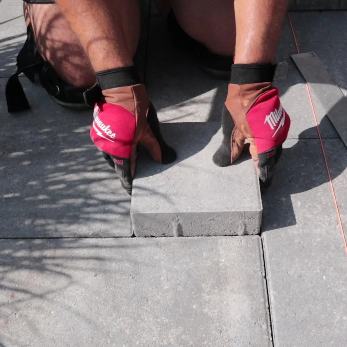 Landscaper putting a final Permacon Melville in a paver patio in Brantford